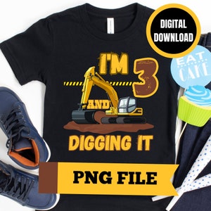 Peut inclure: Un t-shirt noir avec une pelleteuse jaune et le texte "I'm 3 and digging it" en lettres brunes et jaunes. Le chiffre 3 est brun et vieilli. Le t-shirt est un fichier PNG téléchargeable numériquement.