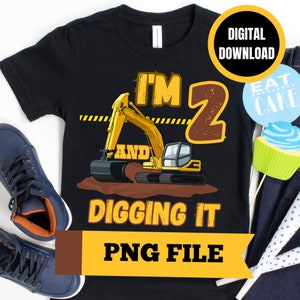 May include: A black t-shirt featuring a yellow excavator and the text "I'm 2 and digging it". The shirt is a digital download and comes as a PNG file.