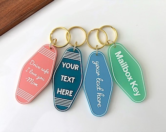 May include: Four motel-style keychains in coral, dark teal, light blue, and mint green. Each features a gold-tone metal ring and white engraved text: Drive safe I love you Mom, YOUR TEXT HERE, your text here, and Mailbox Key with striped accents.