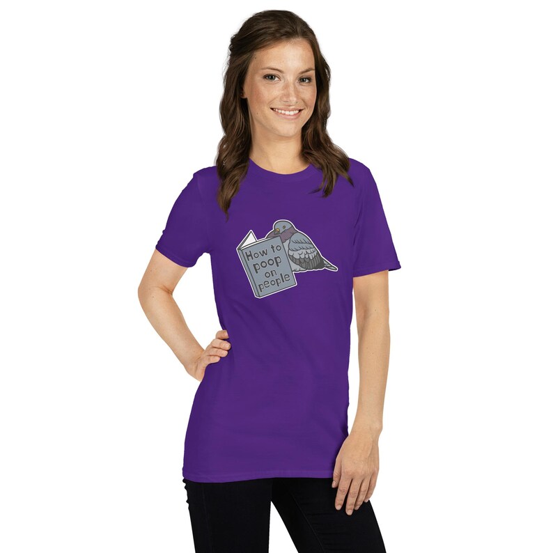 Unisex T-Shirt mit einer Taube die ein Buch liest auf dessen Einband How to poop on people steht.