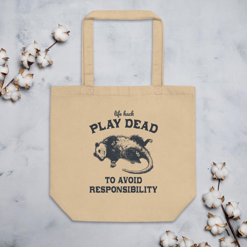 Bio-Stoffbeutel mit einem witzigen Opossum Design und der Aufschrift: Life Hack Play Dead to Avoid Responsibility.