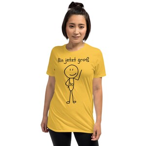 May include: Mustard yellow t-shirt with the text "Bin jetzt gro&szlig;" and a stick figure with the number 30. The stick figure is waving. The shirt is a short-sleeved, crew neck style.