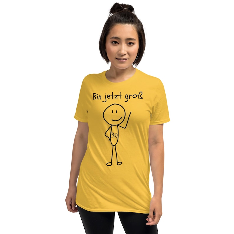 May include: Mustard yellow t-shirt with the text "Bin jetzt gro&szlig;" and a stick figure with the number 30. The stick figure is waving. The shirt is a short-sleeved, crew neck style.