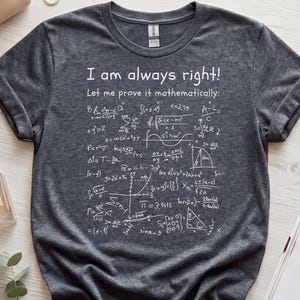 Peut inclure: Un t-shirt gris anthracite à manches courtes avec un texte imprimé en blanc indiquant "I am always right! Let me prove it mathematically:" suivi d'une collection de diverses formules mathématiques, équations et diagrammes géométriques.