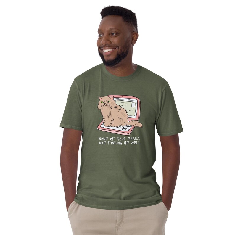 Unisex T-Shirt mit einer grummeligen Katze die auf einem Laptop sitzt und der Aufschrift: None of Your Emails are Finding me Well.