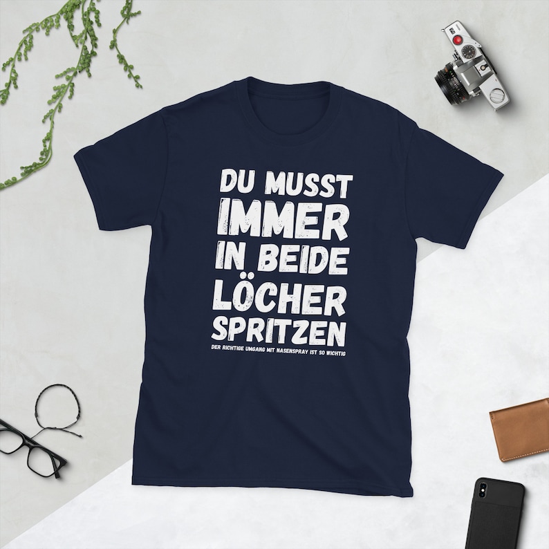 Unisex T-Shirt mit der Aufschrift: Du musst immer in beide Löcher spritzen - Der richtige Umgang mit Nasenspray ist so wichtig.