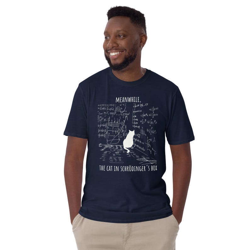 Unisex T-Shirt mit einer Katze, die vor einer Wand aus mathematischen Formeln sitzt und der Aufschrift: Meanwhile, the cat in Schrödingers Box.