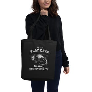 Bio-Stoffbeutel mit einem witzigen Opossum Design und der Aufschrift: Life Hack Play Dead to Avoid Responsibility.