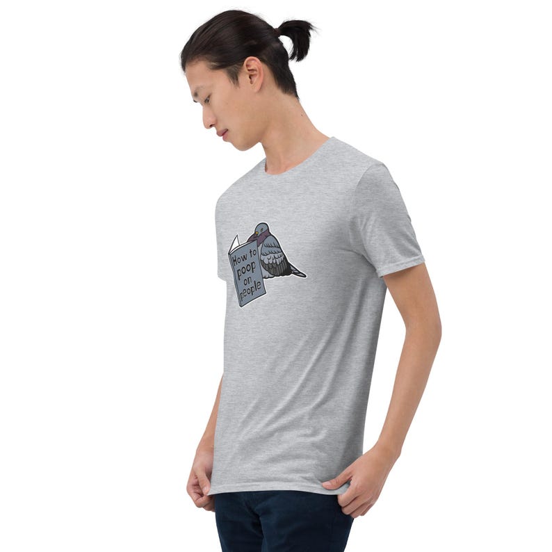 Unisex T-Shirt mit einer Taube die ein Buch liest auf dessen Einband How to poop on people steht.