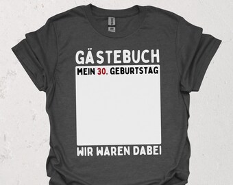 Könnte beinhalten: Dunkelgraues T-Shirt mit weißem Text: "Gästebuch Mein 30. Geburtstag Wir Waren Dabei" über einem großen weißen Rechteck. Das Shirt ist kurzärmlig und hat einen Rundhalsausschnitt.