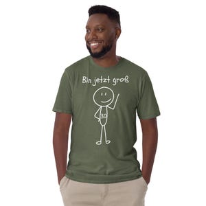 May include: Olive green t-shirt with the text "Bin jetzt gro&szlig;" and a stick figure with the number 30. The stick figure is waving. The t-shirt is made of a soft material.