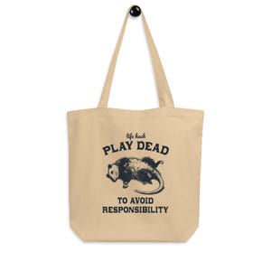 Bio-Stoffbeutel mit einem witzigen Opossum Design und der Aufschrift: Life Hack Play Dead to Avoid Responsibility.