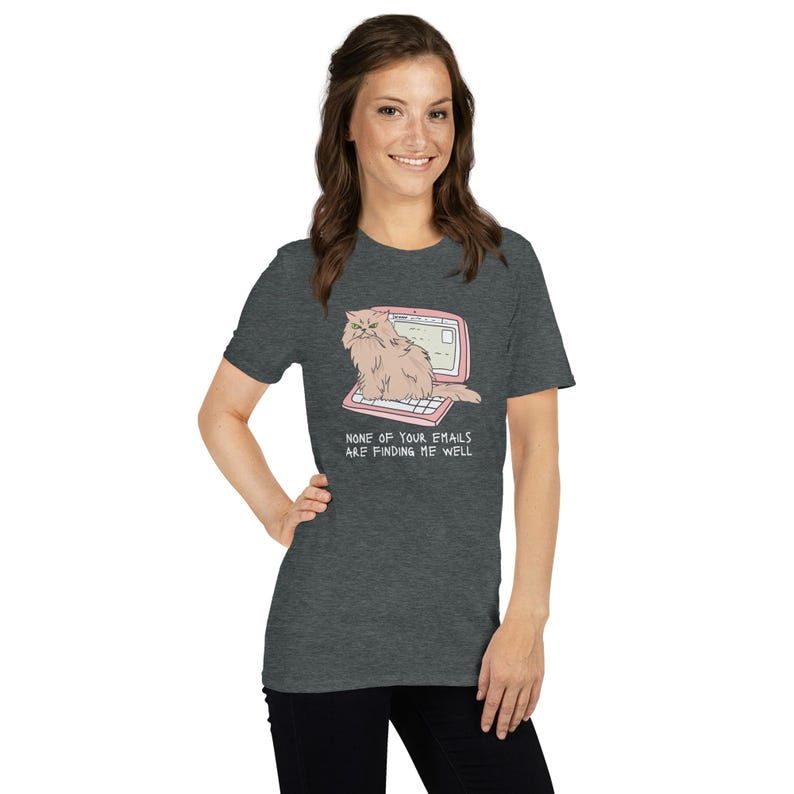Unisex T-Shirt mit einer grummeligen Katze die auf einem Laptop sitzt und der Aufschrift: None of Your Emails are Finding me Well.