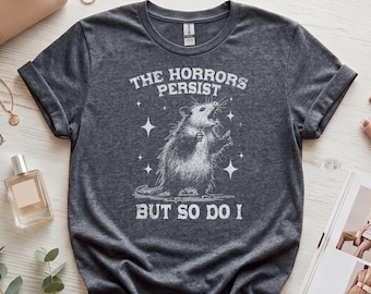 Retro Possum T-Shirt | The Horrors Persist But So Do I | Funny Vintage Opossum Graphic Shirt | Witty Friends Gift Idea | Motivational Tee
