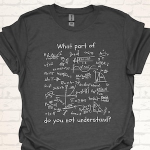 Könnte beinhalten: Ein dunkelgraues T-Shirt mit weißem Text, der "What part of... do you not understand?" lautet. Der Text ist von verschiedenen mathematischen Gleichungen und Symbolen umgeben.