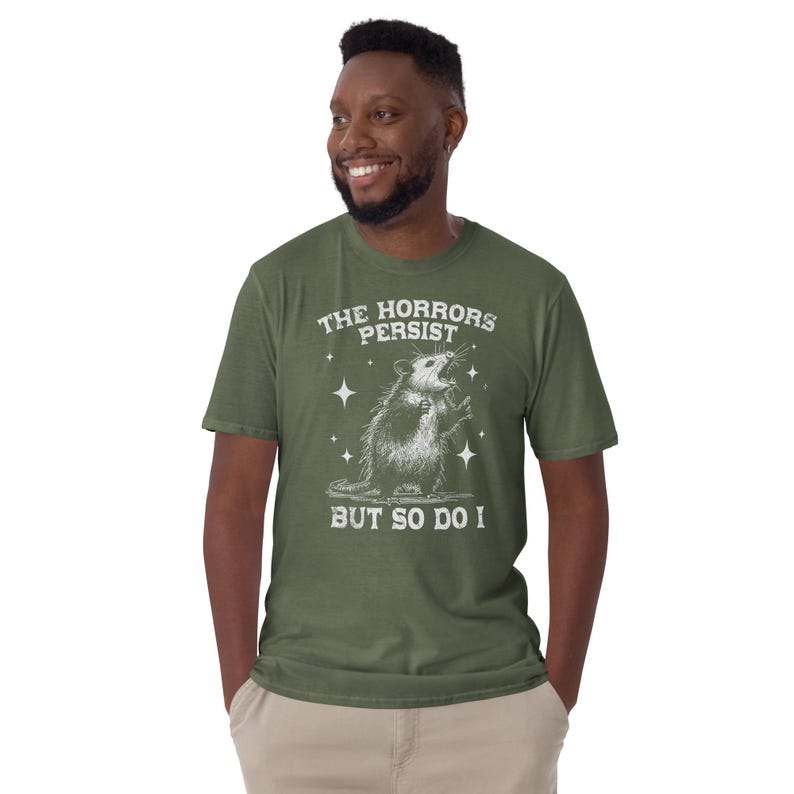 Unisex T-Shirt mit einem schreienden Opossum im Retro Stil und der Aufschrift: The Horrors Persist But so do I.