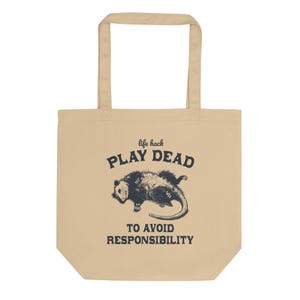 Bio-Stoffbeutel mit einem witzigen Opossum Design und der Aufschrift: Life Hack Play Dead to Avoid Responsibility.