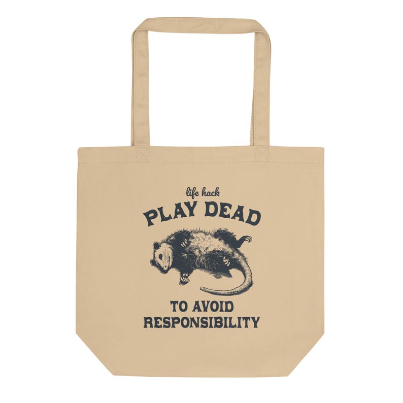 Bio-Stoffbeutel mit einem witzigen Opossum Design und der Aufschrift: Life Hack Play Dead to Avoid Responsibility.