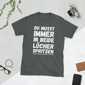 Unisex T-Shirt mit der Aufschrift: Du musst immer in beide Löcher spritzen - Der richtige Umgang mit Nasenspray ist so wichtig.