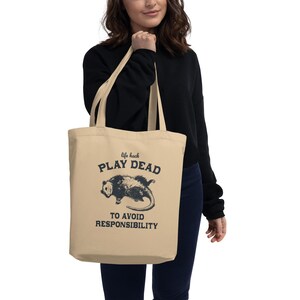 Bio-Stoffbeutel mit einem witzigen Opossum Design und der Aufschrift: Life Hack Play Dead to Avoid Responsibility.