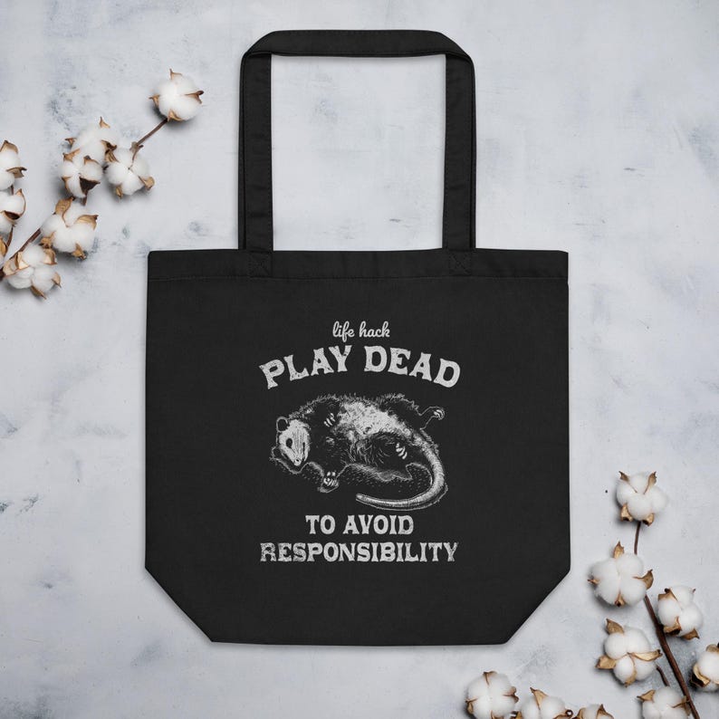 Bio-Stoffbeutel mit einem witzigen Opossum Design und der Aufschrift: Life Hack Play Dead to Avoid Responsibility.