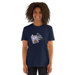 Unisex T-Shirt mit einer Taube die ein Buch liest auf dessen Einband How to poop on people steht.