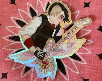 May include: Holographic sticker featuring a musician playing a guitar, with an angel figure. The musician wears a black vest, red wristbands, and a skeleton-gloved hand. The guitar has heart-shaped inlays. The sticker is on a pink bandana background.