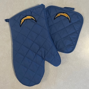 May include: A set of two blue quilted oven mitts with a yellow lightning bolt logo. The mitts are designed for use in the kitchen.