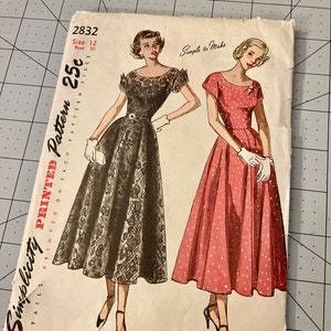 May include: Vintage Simplicity sewing pattern for a dress, size 12, bust 30 inches. The pattern is printed on white paper with black text and illustrations of two women wearing dresses. The dress on the left is black with lace and the dress on the right is pink with white polka dots. The pattern is titled "Simplicity Printed Pattern 25c" and "Simple to Make".