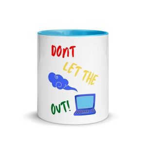 Puede incluir: Taza de cerámica blanca con un borde azul claro. La taza tiene un gráfico de una nube azul con un portátil debajo. El texto "DON'T LET THE OUT!" está escrito en rojo, amarillo y verde.