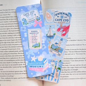 Puede incluir: Dos marcapáginas rectangulares de papel con fondo azul claro que presentan ilustraciones de una tarjeta de club de lectura de Cape Cod, una lista de lectura de verano, libros apilados, un velero, un faro, una langosta y un bolso con texto.