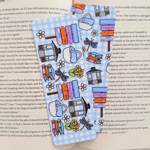May include: Two blue and white patterned bookmarks with illustrations of a basket, dragonfly, books, a gazebo, and a coffee cup. The bookmarks have text that reads "Antiques", "Luke's Diner", and "Stars Hollow".