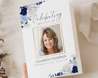 May include: A white memorial card with a gold frame around a photo of a woman. The card has blue and white floral designs and the text "Celebrating the life of Elizabeth Thompson September 14, 1970 - May 01, 2020".