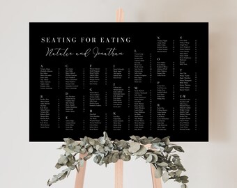 May include: Black and white wedding seating chart with the text "Seating for Eating Natalie and Jonathan". The chart lists guest names and table assignments in alphabetical order.