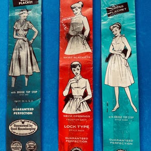 May include: Three vintage Serval zipper packages. The packages are in blue and red, featuring illustrations of women's dresses and text such as "Dress Placket" and "Guaranteed Perfection." Made in the U.S.A.