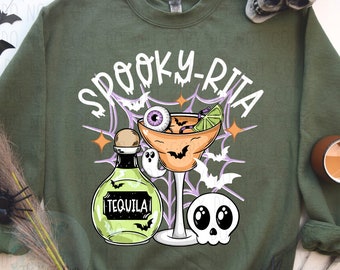 May include: Green sweatshirt with a spooky-rita design. The design features a margarita glass with a lime wedge, an eyeball, and bats. There is also a bottle of tequila with a ghost and a skull.