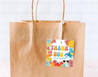 May include: A brown paper gift bag with a colorful thank you tag. The tag features a cartoon sun, a shark, a crab, and a beach ball. The text on the tag reads "Thank You xoxo, Charlie".