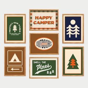 Peut inclure: Ensemble de tirages d'art encadrés sur le thème du camping. Les tirages présentent des textes tels que "Happy Camper" et "Outdoors", ainsi que des illustrations d'arbres et de symboles de camping. La palette de couleurs comprend des verts, des bruns et des oranges.