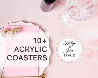 May include: 10+ acrylic coasters with a personalized design that says "Kaitlyn & John 13.08.23". The coasters are on a pink surface with a white plate and a glass of wine.