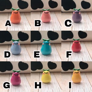 May include: Nine small pear-shaped figurines with different colors and facial expressions. The figurines are made of polymer clay and have a glossy finish. The colors include orange, pink, purple, light blue, turquoise, red, magenta, yellow, and orange.