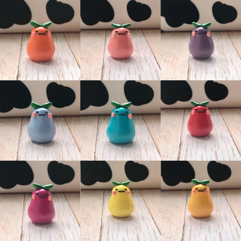 May include: Nine pear-shaped figurines with different colors and facial expressions. Each figurine has a green leaf on top. The figurines are arranged in three rows of three.