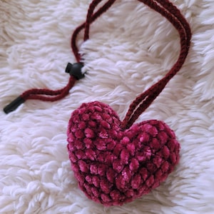 May include: A burgundy crocheted heart charm on a burgundy cord with a black clasp.