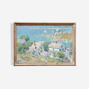 Puede incluir: Una pintura de paisaje enmarcada representa un pueblo costero con casas blancas, follaje verde y un mar azul salpicado de veleros. La obra de arte está en un marco de madera, mostrando un estilo impresionista sereno.