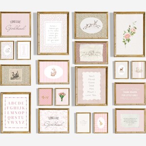 May include: A collection of framed art prints in gold frames. The prints feature various designs, including text, floral arrangements, and animal illustrations. The color palette is soft, with pink and white tones.