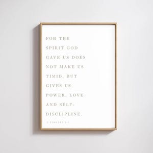 Op de afbeelding: Een ingelijste print met een licht houten frame. De print bevat tekst in een schreefletter, met de tekst "FOR THE SPIRIT GOD GAVE US DOES NOT MAKE US TIMID, BUT GIVES US POWER, LOVE AND SELF-DISCIPLINE. 2 TIMOTHY 1:7."