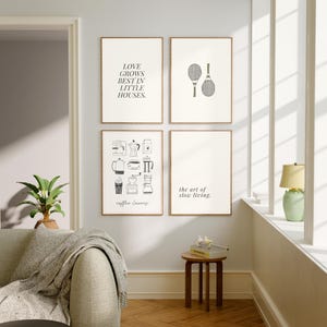 May include: Four framed art prints with minimalist designs. One print reads "LOVE GROWS BEST IN LITTLE HOUSES." Another features tennis rackets. A third displays coffee-related illustrations, and the last says "the art of slow living."