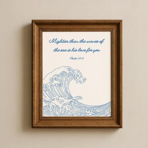 Könnte beinhalten: Gerahmtes Kunstwerk mit hellbeigem Hintergrund. Es zeigt eine blaue Wellenillustration und den Text: "Mächtiger als die Wellen des Meeres ist seine Liebe zu dir, Psalm 93:4." Der Rahmen ist dunkelbraun.