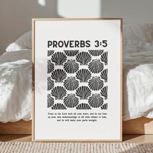 May include: A framed print with the text "PROVERBS 3:5" in bold black letters. The print features a pattern of black seashell illustrations on a white background. Below the title is a quote from Proverbs.