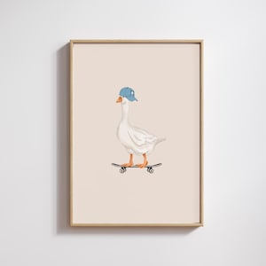 May include: A framed print featuring a white goose wearing a blue baseball cap and riding a skateboard. The goose has orange feet and a yellow beak. The background is a solid light beige color.