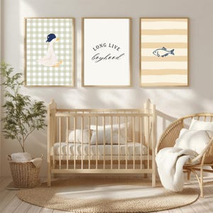 May include: Three framed prints with a nursery theme. One print features a goose wearing a cap on a green and white checkered background. Another print has the text "LONG LIVE boyhood". The third print has a fish on a striped background.